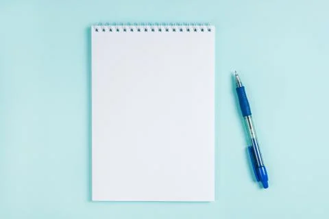 Flatlay notebook and pen on a table on a blue background. Mock up Stock Photos