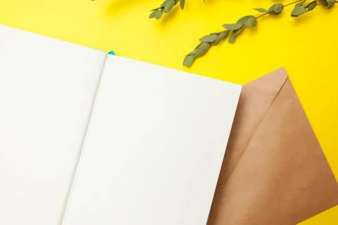 Flatlay of open notepad with envelope and dry leaves Foto stock