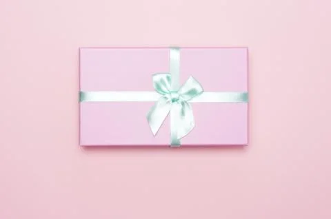 Flatlay with pink gift box with minty atlas ribbon on pink background Stock Photos