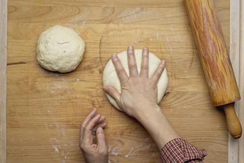 Flatlay of pressing down a ball of dough. Stock Photos