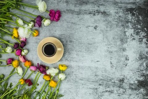 Flatlay of spring flowers and cup of black coffee on grey marble background with Stock Photos