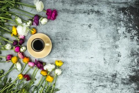 Flatlay of spring flowers and cup of black coffee on grey marble background with Foto stock