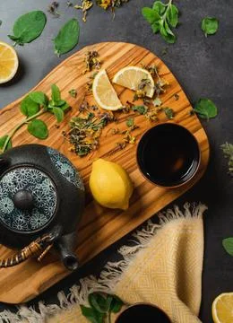 Flatlay tea pot with herbs and lemon and honey on wooden board Stock Photos