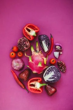 Flatlay of various red, violet and pink fruits and vegetables knolled togethe Stock Photos