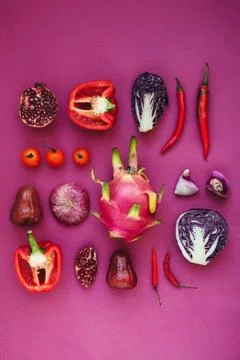 Flatlay of various red, violet and pink fruits and vegetables knolled togethe Stock Photos
