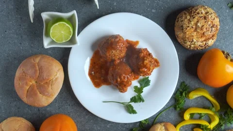 Flatlay video of chef serving meatballs with tomato sauce and assorted ingr.. Stock Footage 321348437