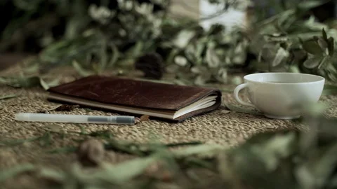 Flatlay with a wicker mat, dry plants, a notebook and a cup of coffee. Close-up Stock Footage 124861796