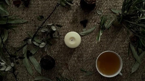 Flatlay with wicker mat, dry plants, a candle and a cup of herbal tea. Close-up Stock Footage 124861853