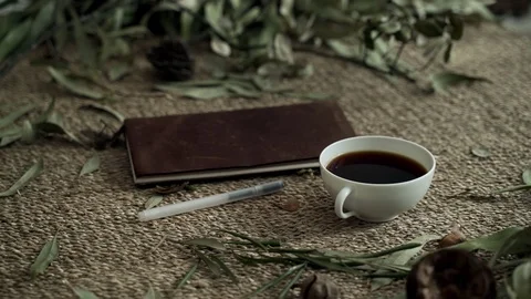 Flatlay with a wicker mat, dry plants, a notebook and a cup of coffee. Close-up Stock-Footage 124862189