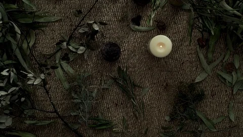 Flatlay with wicker mat, dry plants, and a burning candle. Blew out the candle Stock Footage 124862314