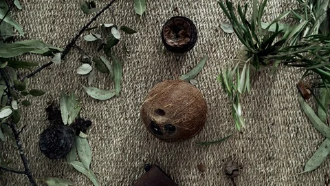 Flatlay with wicker mat, dry plants, a burning candle and a coconut. Closeup of Stock Footage 124862738