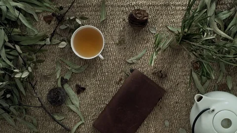 Flatlay with a wicker mat, dry plants, a notebook and a cup of coffee. Close-up Stock Footage 124862883