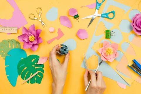 Flatlay with woman's hands making beautiful floral papercraft with other art  Stock Photos