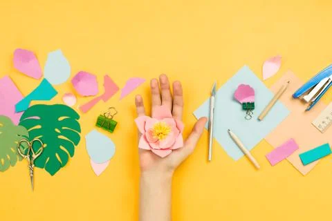 Flatlay with woman's hands making beautiful floral papercraft with other art  Stock Photos