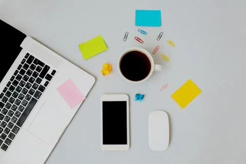 Flatlay of workspace with laptop, coffee, mobile phone and stickers. Stock Photos
