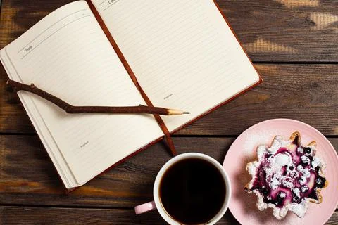 Flatley layout. Open notebook, vintage twig pen, black coffee in a cup and ca Stock Photos