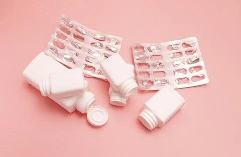 Flatly empty plate with pills, capsule, vitamin bottles, containers on pink Stock Photos