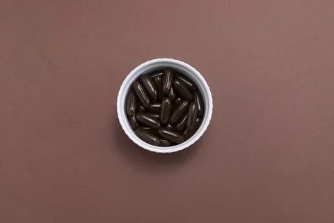 Flatly Sunflower Lecithin Brown Softgel Pill Capsule In White Bowl On Brown Stock Photos