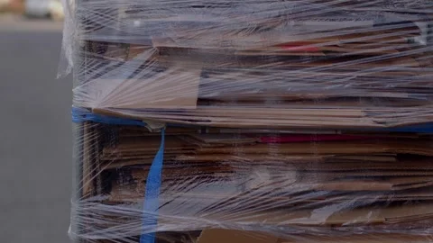 Flattened cardboard boxes stack on pallet with blue stretch wrap Stock Footage 347205390