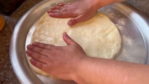 Flattening and Shaping Bread Dough by Hand on a Round Metal Tray Stock Footage 344786321