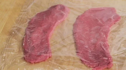 Flattening a veal escalope wrapped in cling film Vídeos de archivo 24663282