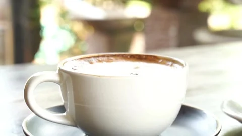 Flavored coffee in a mug on wooden table at coffee shop. 動画素材 334648889