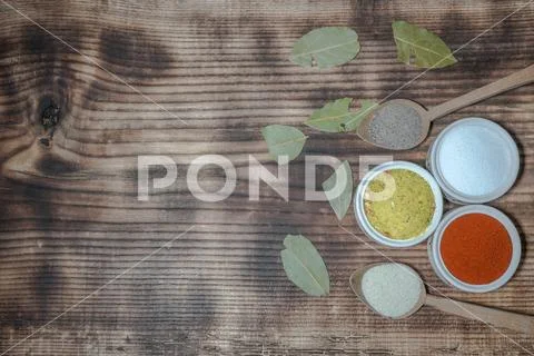 Flavorings in bowls and charcoal leafs Stock Photos