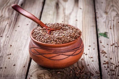 Flax seeds in bowl on a wooden table Stock Photos