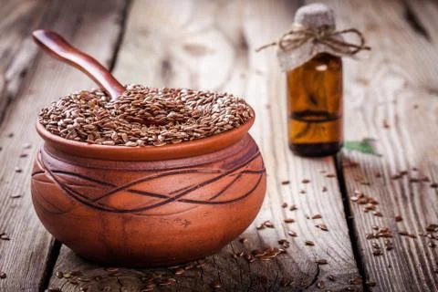 Flax seeds in bowl on a wooden table Stock Photos