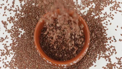 Flax Seeds Falling from Container - Close-Up View Stock Footage 303499693