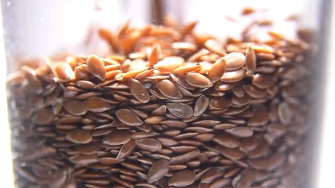 Flax seeds pouring into glass macro Stockbeeldmateriaal 123174553