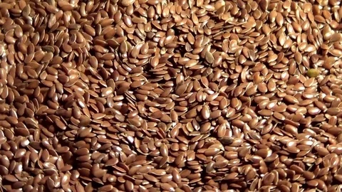 Flax seeds rotating and falling , close up overhead view Stock Footage 70861076