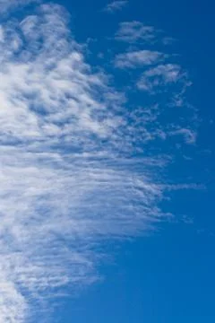 Fleecy clouds against a background blue sky Stock Photos