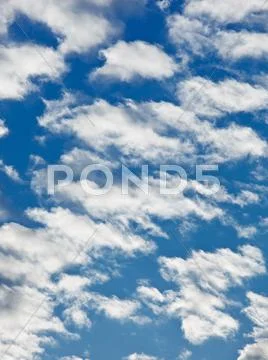 Fleecy clouds on blue sky background Stock Photos