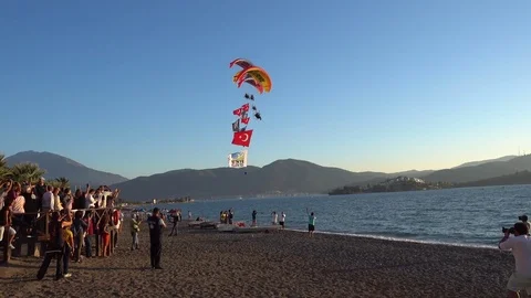 Fleet of paramotors fly above people on the beach Stock Footage 81304791