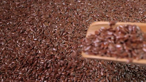 Flex seed flaxseed drop pour from wooden spoon scoop  Stock Footage 157899079