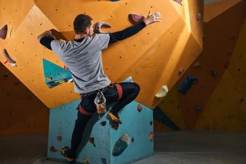 Flexible athletic climber without forearm training hard in bouldering gym Stock Photos