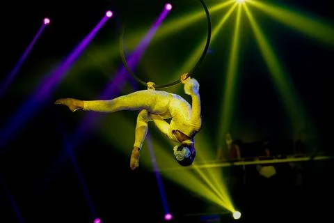 Flexible female acrobat do back stretching element upside down on aerial hoop Stock Photos