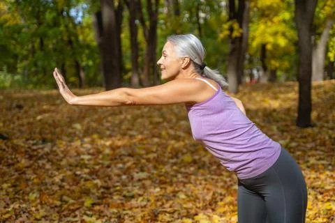 Flexible female doing a back exercise outdoors Foto stock