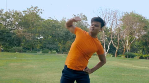 Flexible Indian man practicing stretching exercise in a green area - healthy ... Stock Footage 154297001