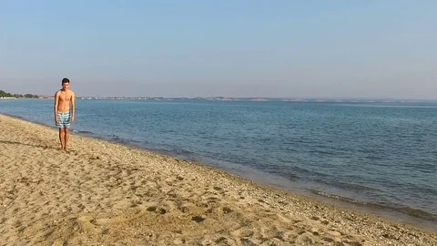 Flexible Talented Boy doing gymnastic on the beach Stock Footage 84742757