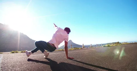 Flexible teen practicing some slow motion breakdancing in a road Stock Footage 48417181
