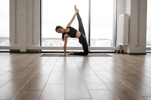 Flexible woman doing Ashtanga yoga practice indoors Stock Photos