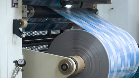 Flexo printing. Printing house. Large roll rotates rapidly. Film spins between Stock Footage 234609119