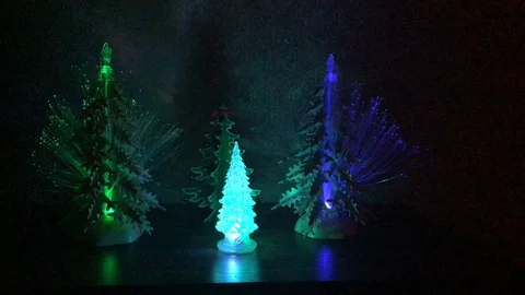 Flickering artificial Christmas trees on the table Stock Footage 100561621