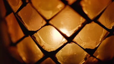 Flickering candle in a glass with diamond pattern, closeup Stock Footage 269219210