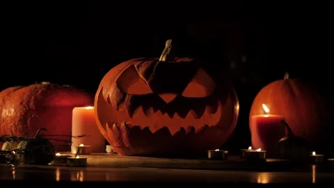 Flickering carved pumpkins, head Jack O Lanterns with burning candle inside i Stock Footage 272460238