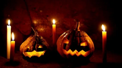 Flickering carved pumpkins, head Jack O Lanterns with burning candle inside i Stock Footage 272460917
