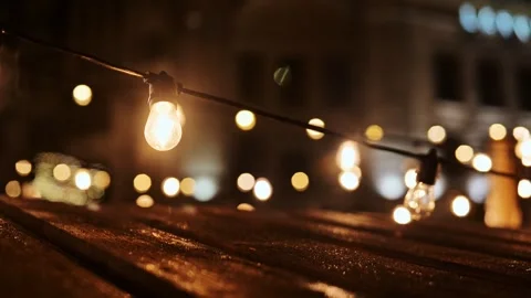 Flickering Christmas Light Bulb on String in Warm Festive Night City Ambience Stock Footage 320516543