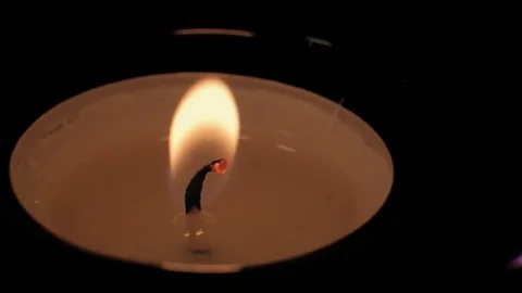 Flickering flame from burning candle tealight wick Stock Footage 73953727